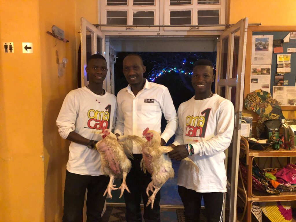 Omacan staff member with two young men